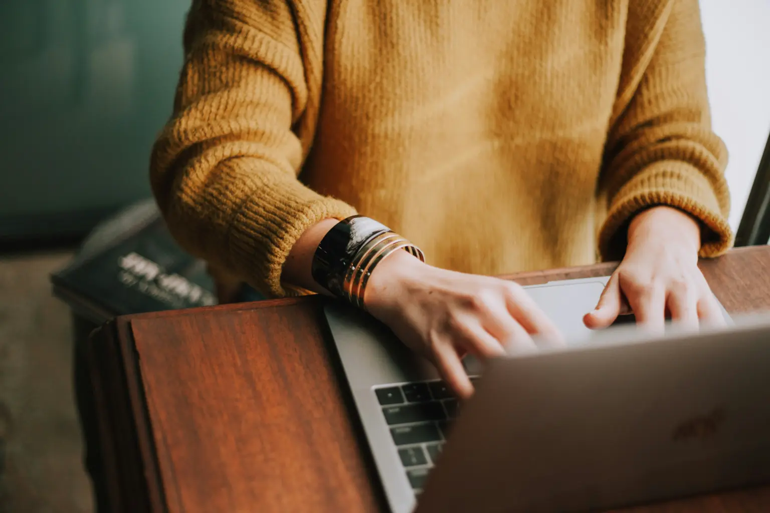 Osoba pracująca na laptopie i sprawdzająca stronę w ramach opieki nad stroną internetową.